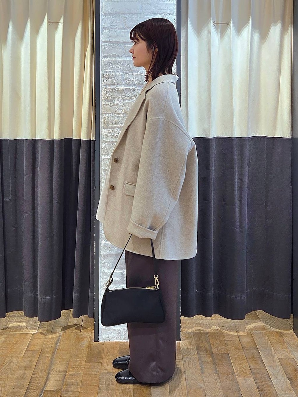 ブラック系のローファー、ブラック系のショルダーバッグ、ベージュ系のテーラードジャケットを着用したレディースの秋コーディネートの3枚目の写真