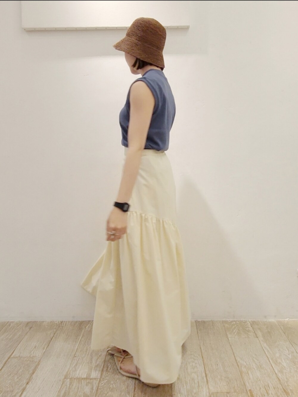 ブルー系のタンクトップ、ホワイト系のスカート、ホワイト系のサンダルを着用したレディースの夏コーディネートの2枚目の写真