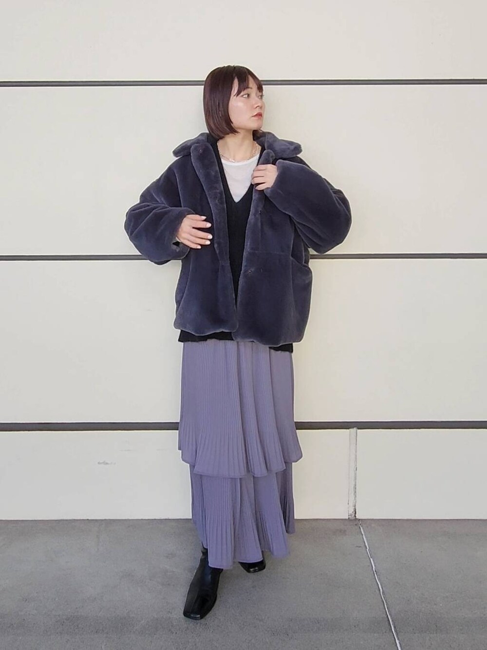 グレー系のスカート、グレー系のその他アウター、ブラック系のニット/セーターを着用したレディースの冬コーディネートの4枚目の写真