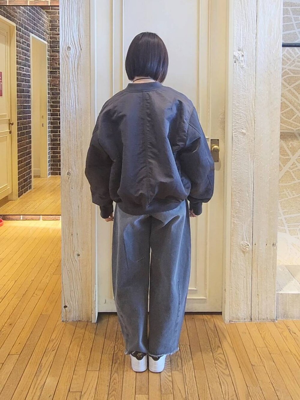 グレー系のワンピース、グレー系のMA-1、グレー系のデニムパンツを着用したレディースの冬コーディネートの3枚目の写真