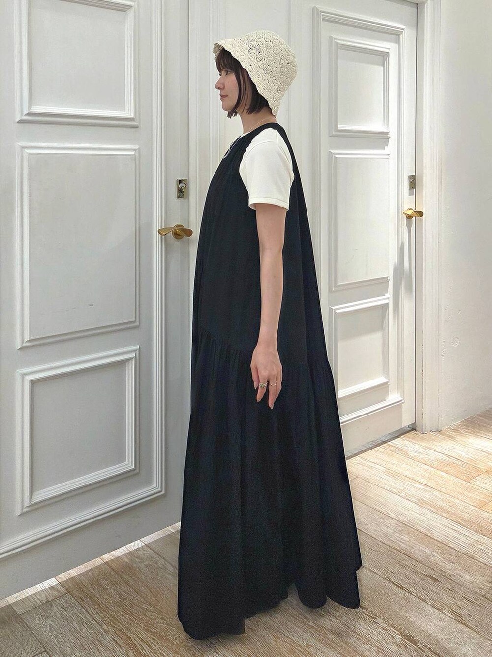ブラック系のサンダル、ホワイト系のTシャツ/カットソー、ブラック系のワンピースを着用したレディースの春コーディネートの2枚目の写真