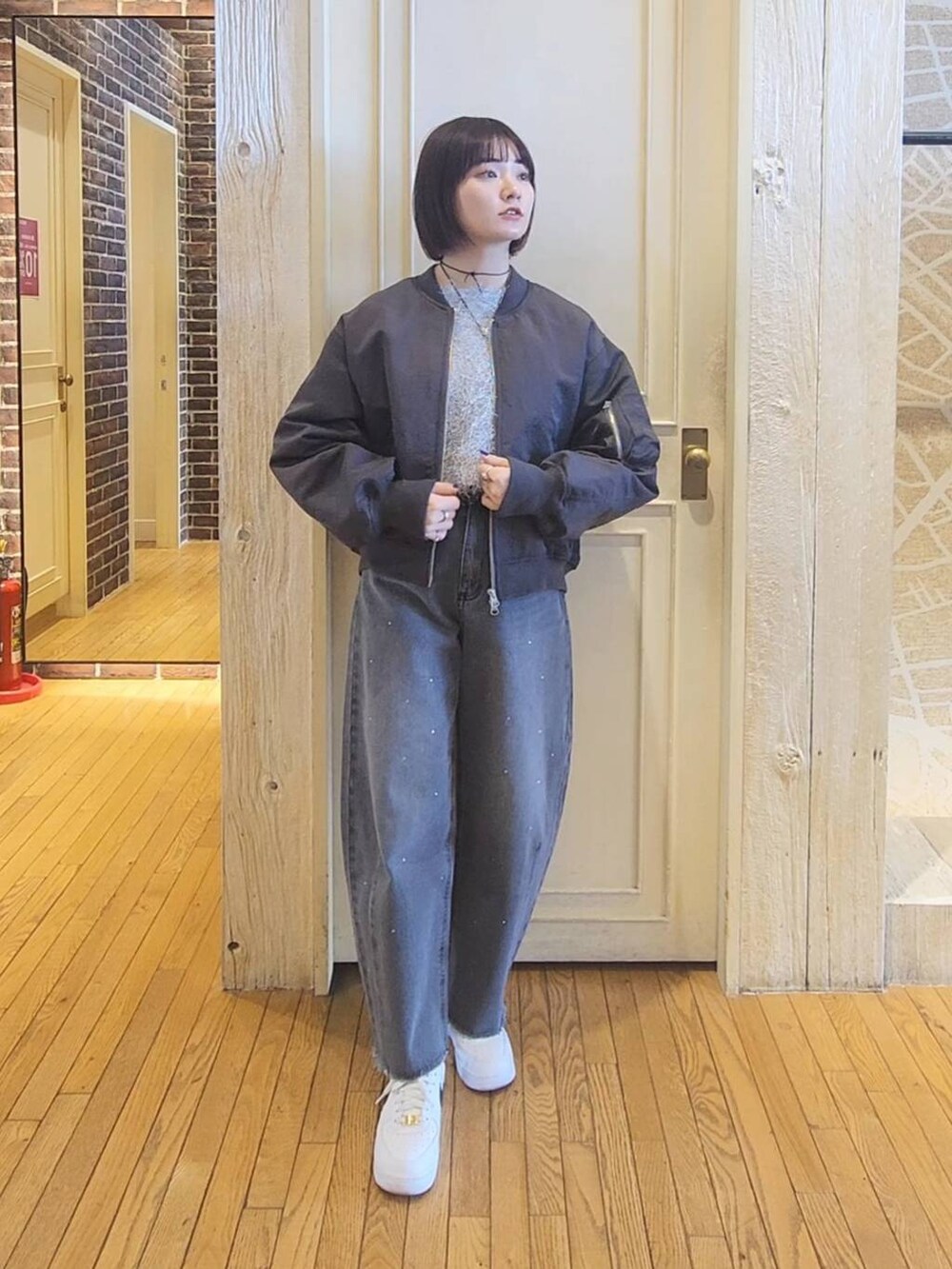 グレー系のワンピース、グレー系のMA-1、グレー系のデニムパンツを着用したレディースの冬コーディネートの4枚目の写真