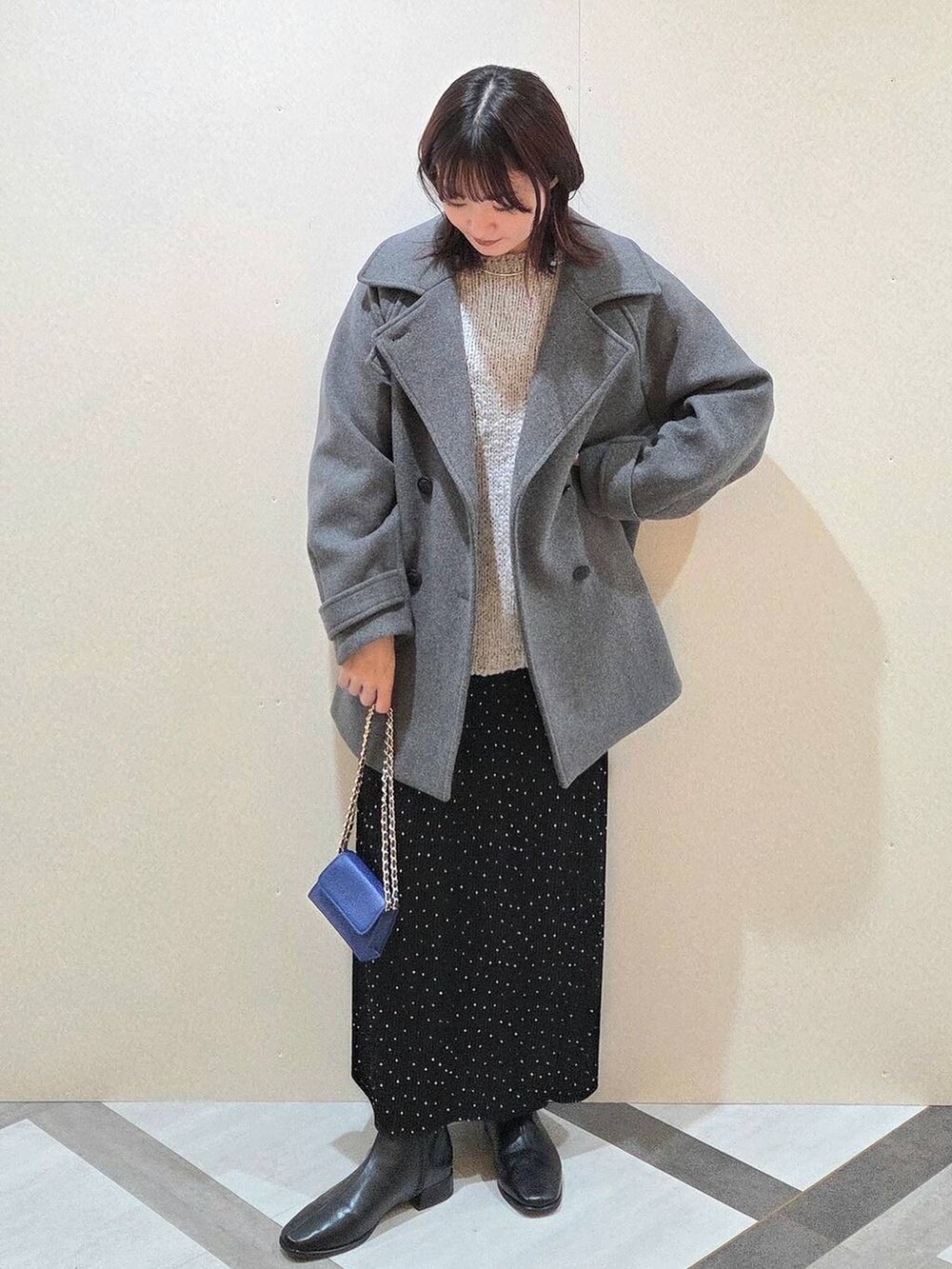 グレー系のピーコート、その他のスカート、ブラック系のブーツを着用したレディースの秋コーディネートの5枚目の写真