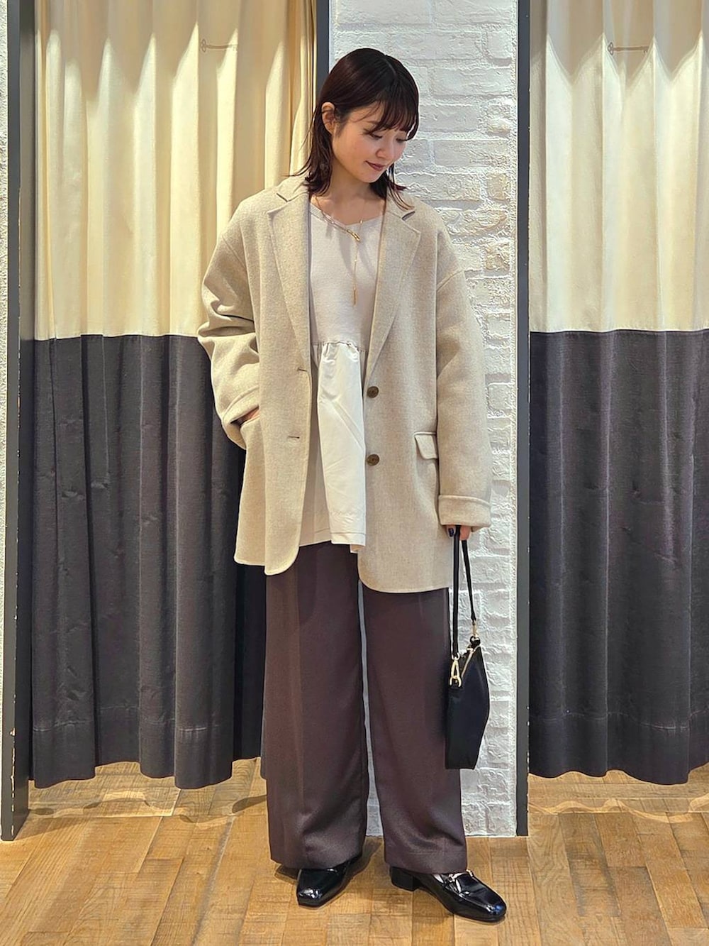 ブラック系のローファー、ブラック系のショルダーバッグ、ベージュ系のテーラードジャケットを着用したレディースの秋コーディネートの5枚目の写真