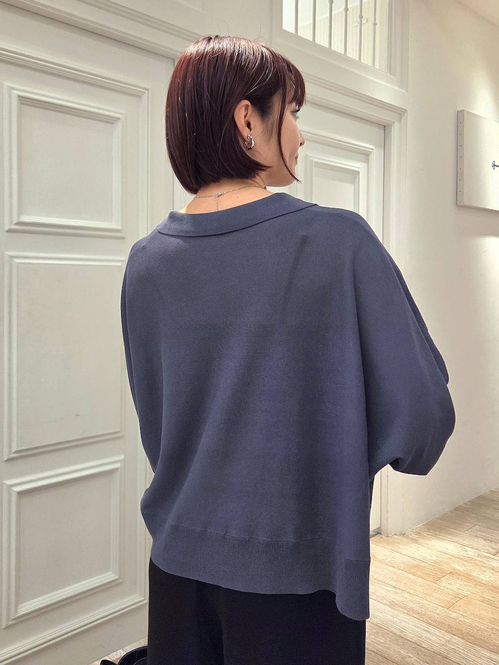 ブラック系のスラックス、ブラック系のショルダーバッグ、グレー系のニット/セーターを着用したレディースの春コーディネートの5枚目の写真