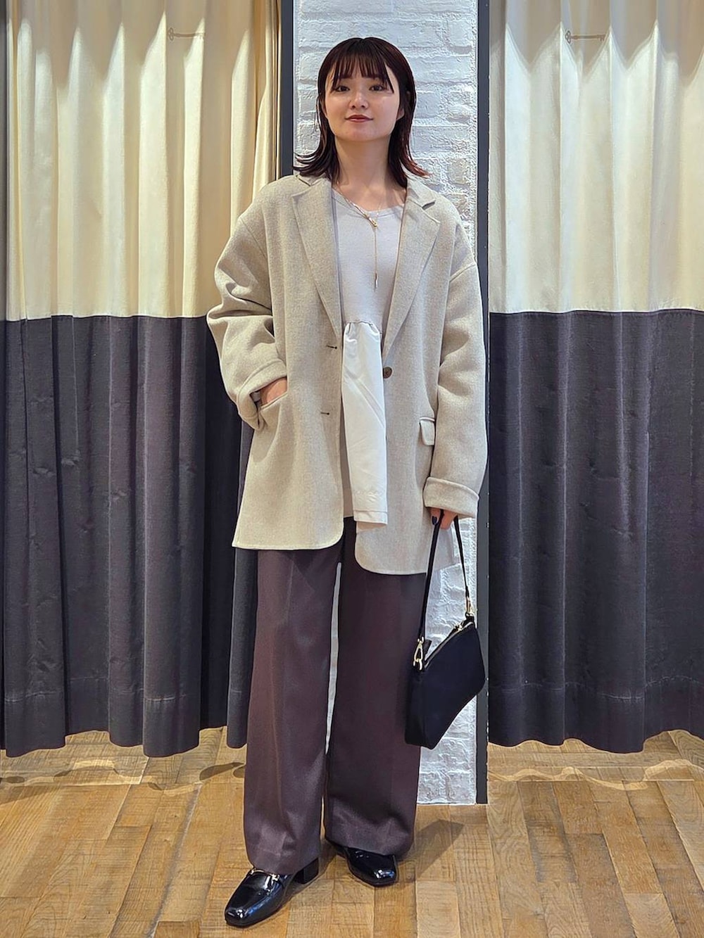 ブラック系のローファー、ブラック系のショルダーバッグ、ベージュ系のテーラードジャケットを着用したレディースの秋コーディネートの6枚目の写真