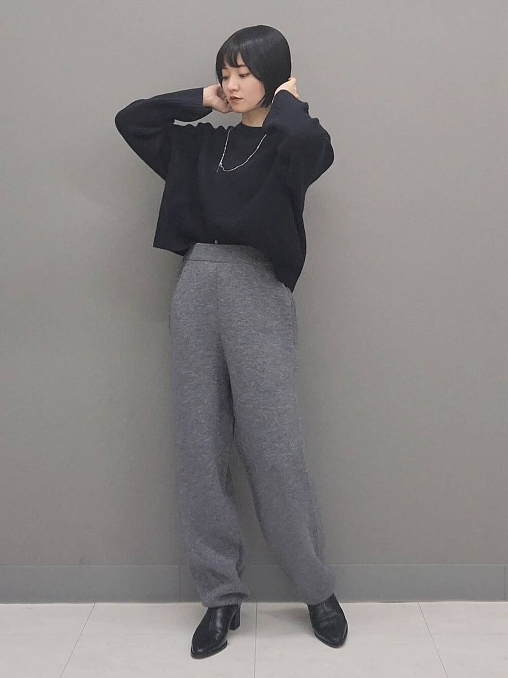 ブルー系のニット/セーター、グレー系のその他パンツ、ブラック系のブーツを着用したレディースの秋コーディネートの3枚目の写真