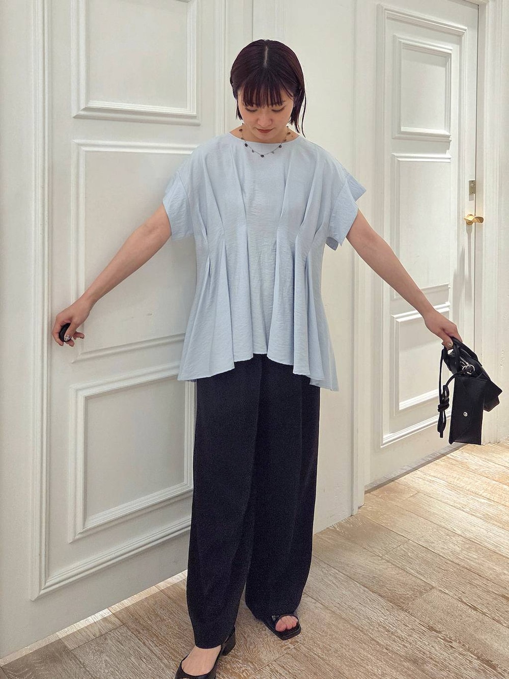 ブルー系のシャツ/ブラウス、ブラック系のスラックス、ブラック系のパンプスを着用したレディースの夏コーディネートの4枚目の写真