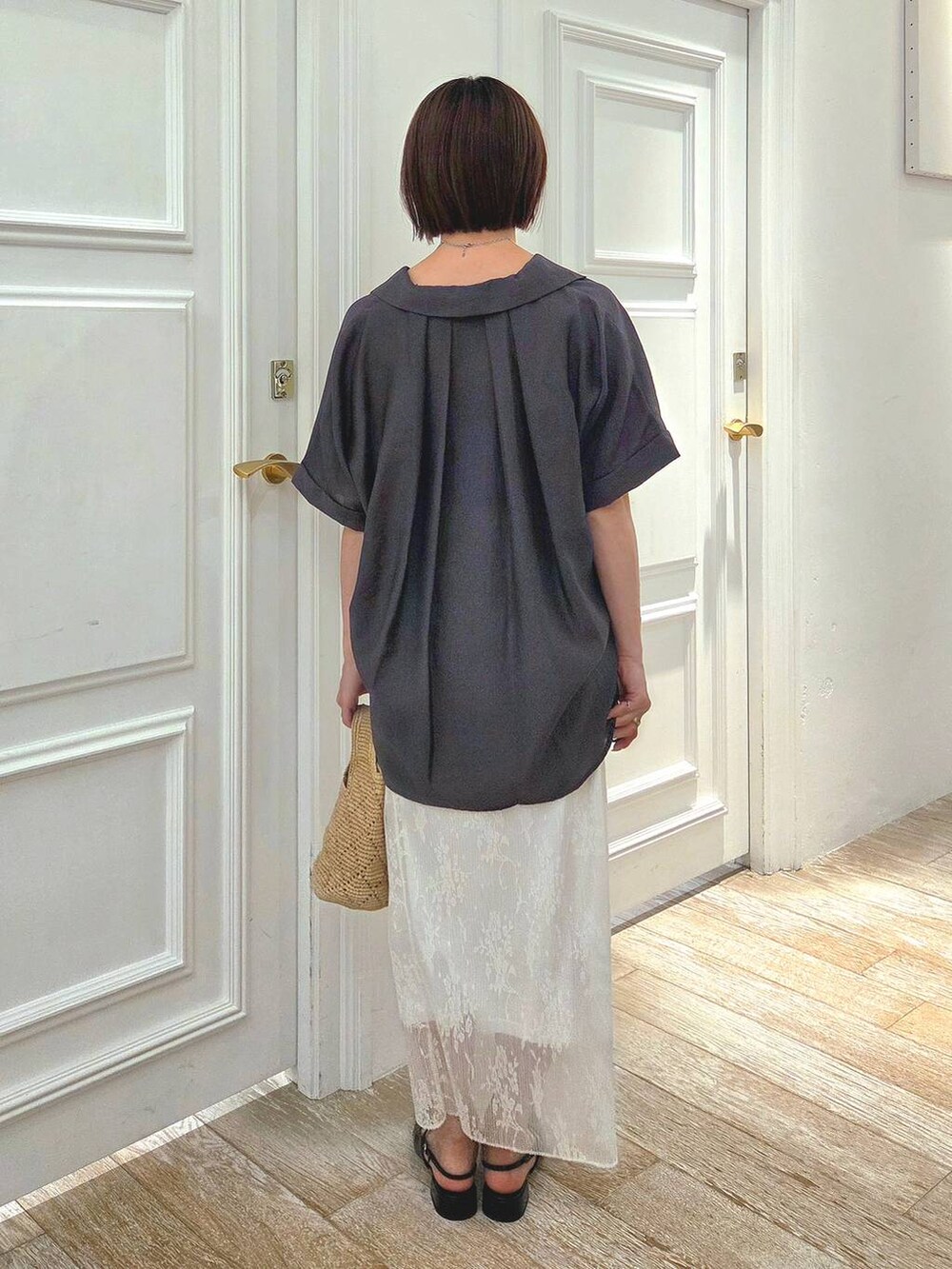 ホワイト系のスカート、グレー系のシャツ/ブラウス、ブラック系のパンプスを着用したレディースの春コーディネートの3枚目の写真