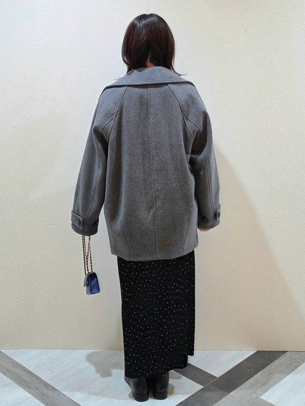 グレー系のピーコート、その他のスカート、ブラック系のブーツを着用したレディースの秋コーディネートの4枚目の写真