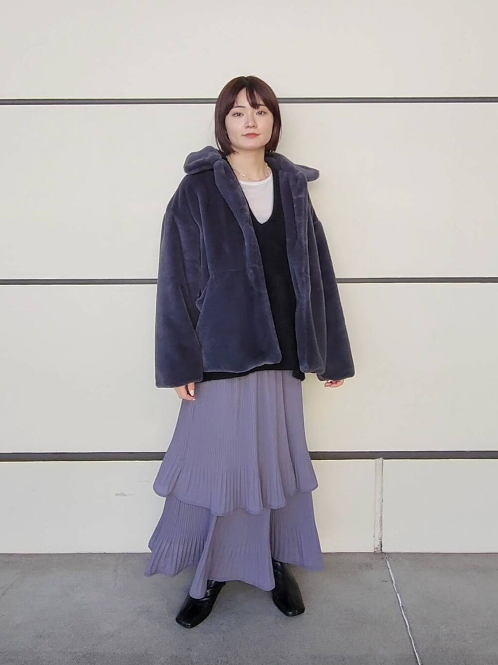 グレー系のスカート、グレー系のその他アウター、ブラック系のニット/セーターを着用したレディースの冬コーディネートの2枚目の写真