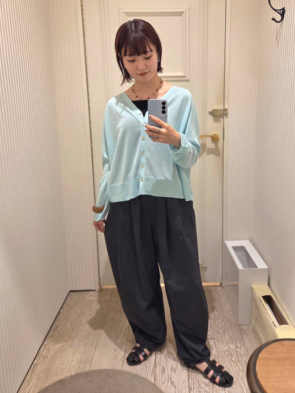 ブラック系のサンダル、ブルー系のカーディガン/ボレロ、ブラック系のその他パンツを着用したレディースの春コーディネートの2枚目の写真