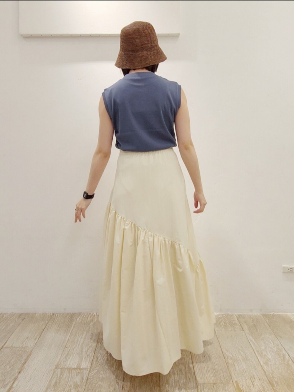 ブルー系のタンクトップ、ホワイト系のスカート、ホワイト系のサンダルを着用したレディースの夏コーディネートの3枚目の写真