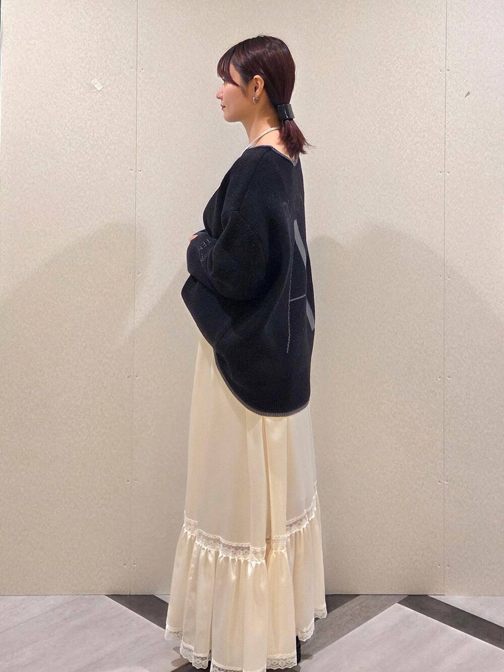 ブラック系のローファー、ブラック系のショルダーバッグ、ホワイト系のスカートを着用したレディースの秋コーディネートの3枚目の写真