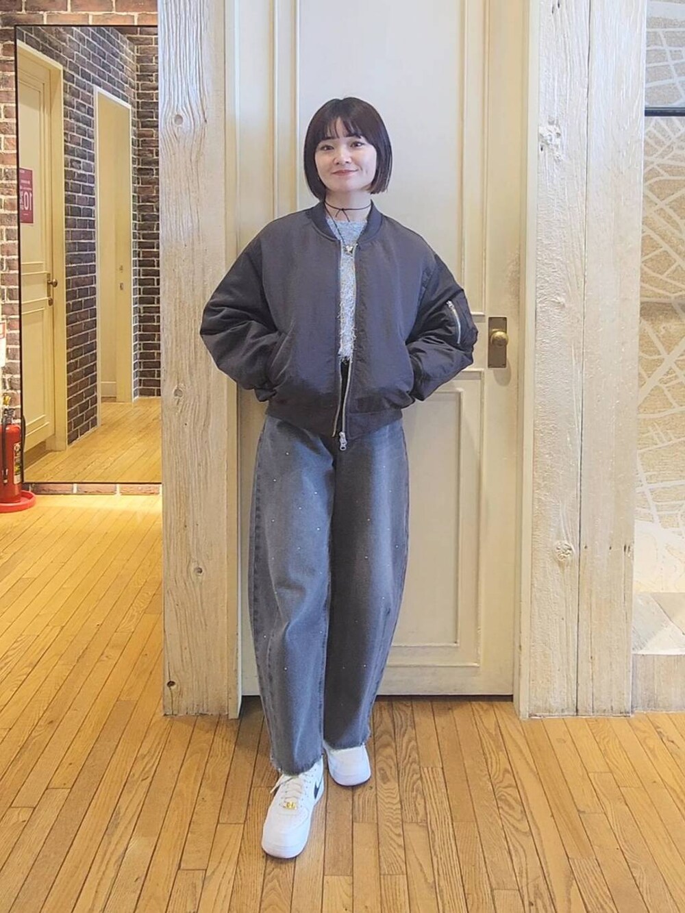 グレー系のワンピース、グレー系のMA-1、グレー系のデニムパンツを着用したレディースの冬コーディネートの5枚目の写真