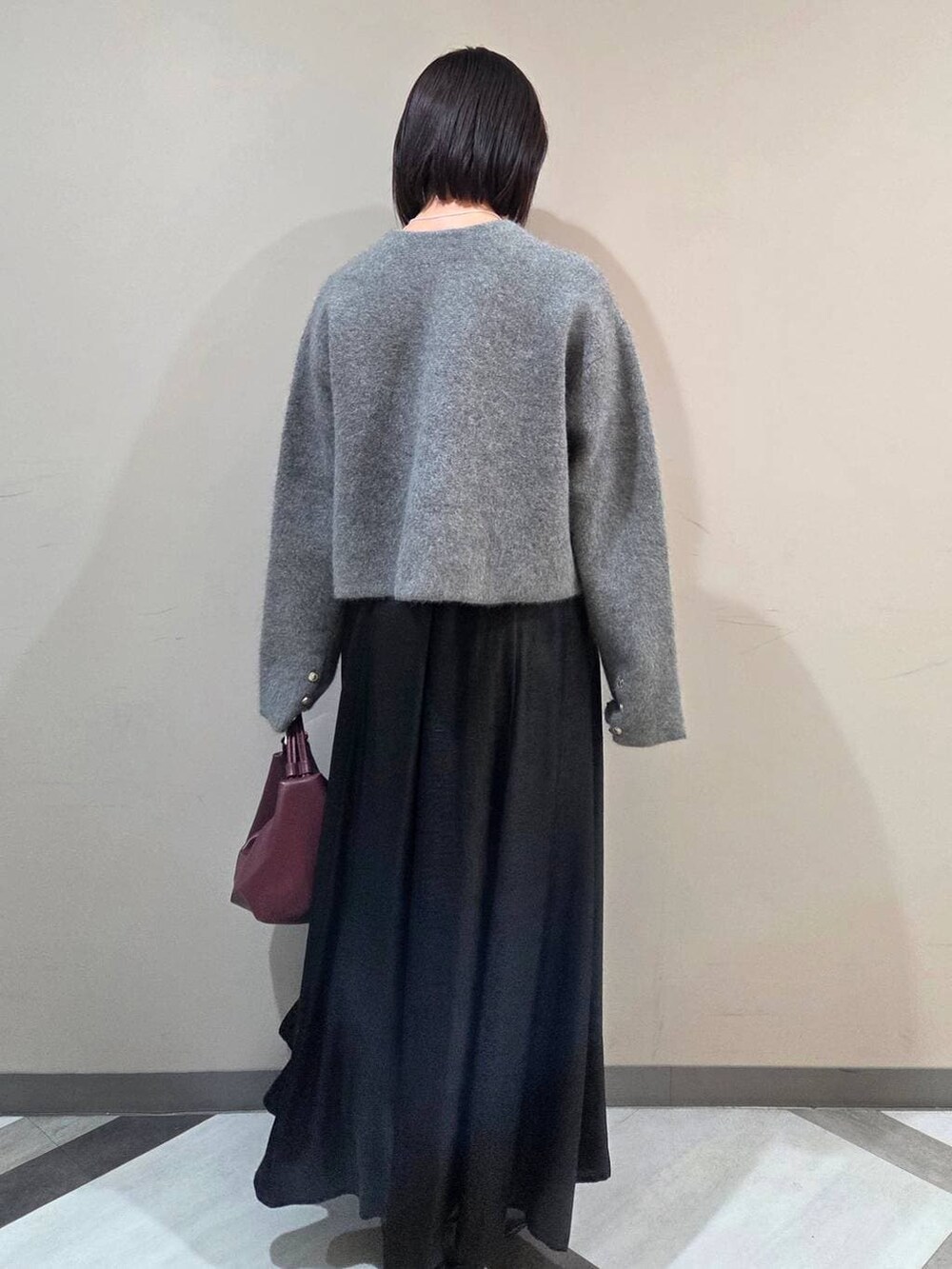 グレー系のカーディガン/ボレロ、ブラック系のブーツ、ベージュ系のショルダーバッグを着用したレディースの秋コーディネートの3枚目の写真