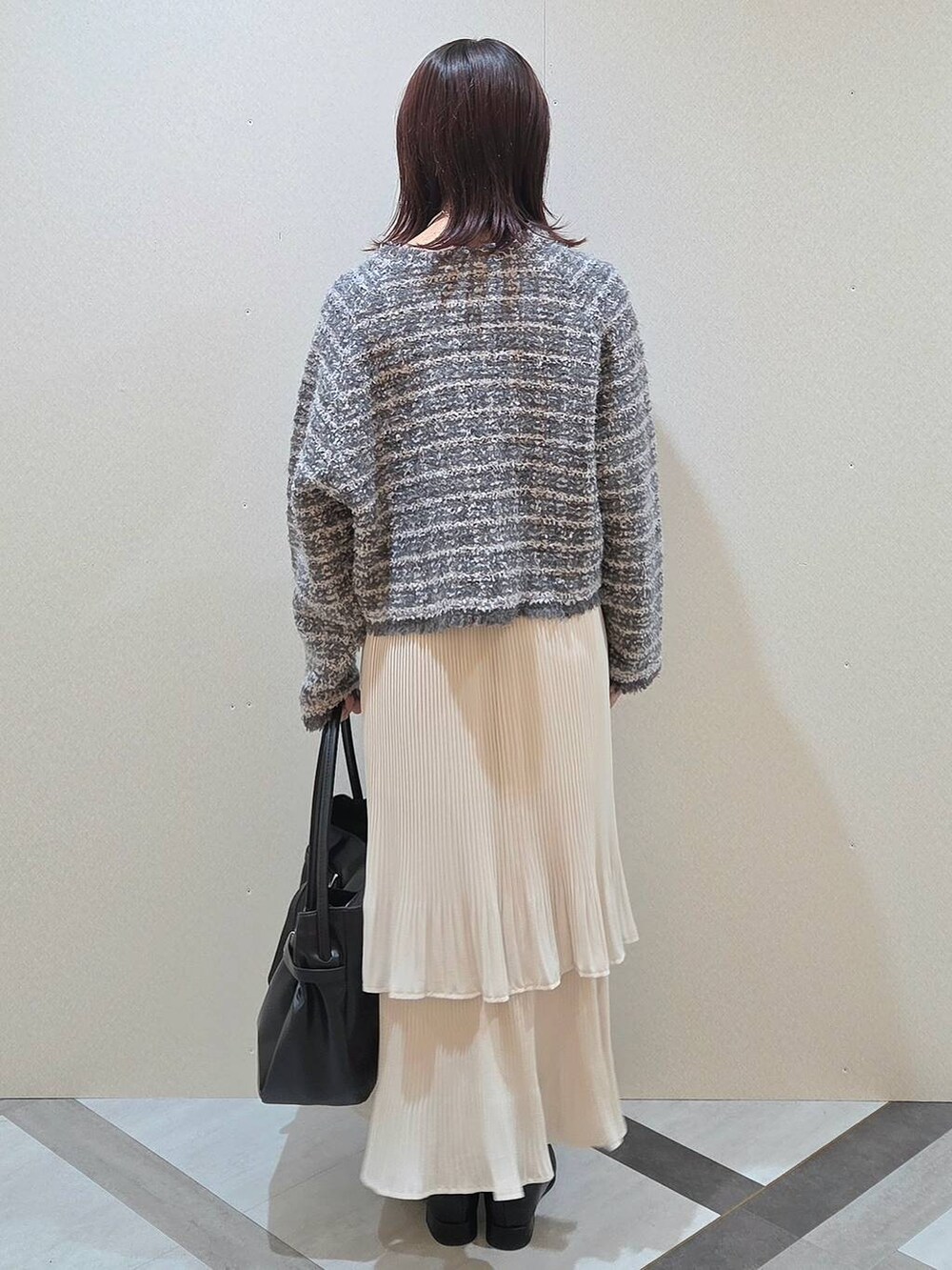 ホワイト系のスカート、ブラック系のブーツ、グレー系のカーディガン/ボレロを着用したレディースの秋コーディネートの4枚目の写真