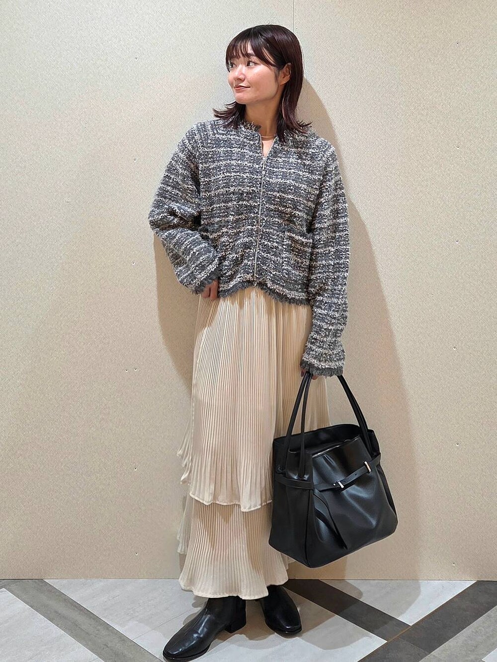 ホワイト系のスカート、ブラック系のブーツ、グレー系のカーディガン/ボレロを着用したレディースの秋コーディネートの5枚目の写真