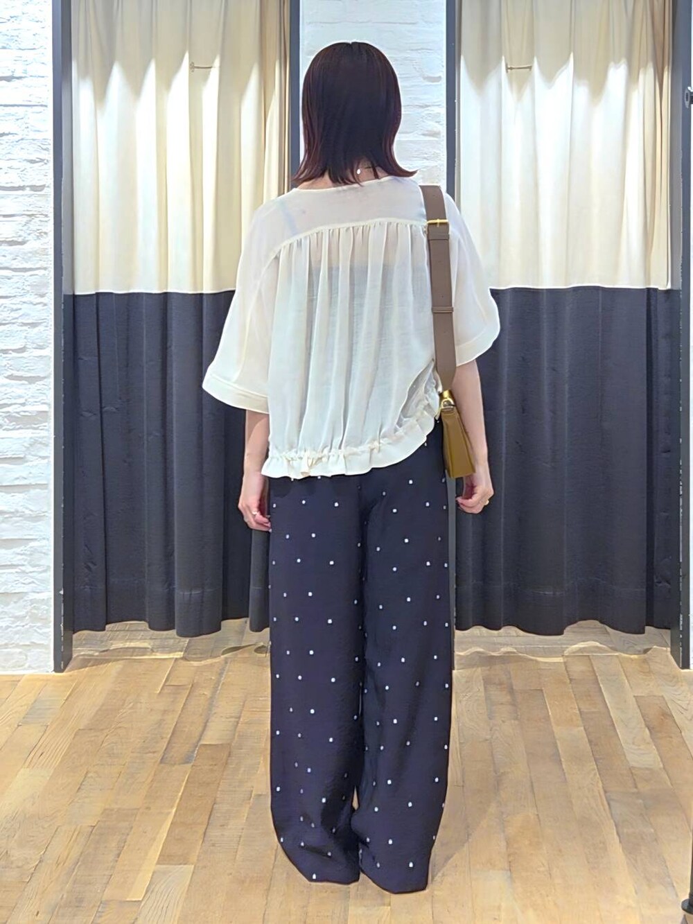 ブラック系のサンダル、ブラック系のその他パンツ、ホワイト系のブルゾンを着用したレディースの夏コーディネートの3枚目の写真