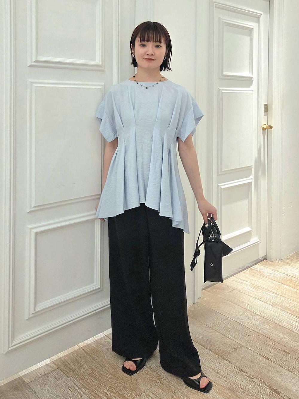 ブルー系のシャツ/ブラウス、ブラック系のスラックス、ブラック系のパンプスを着用したレディースの夏コーディネートの6枚目の写真