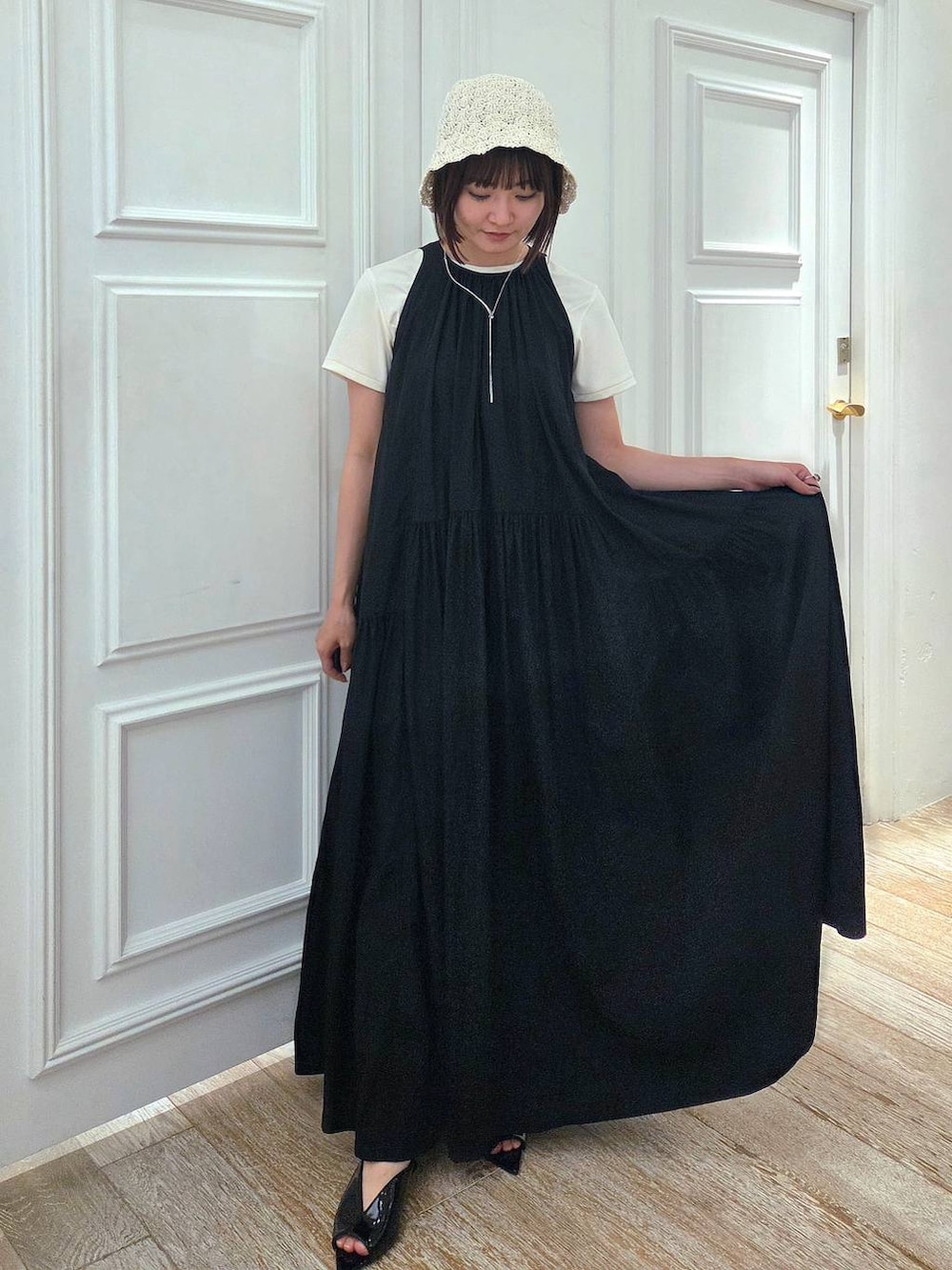 ブラック系のサンダル、ホワイト系のTシャツ/カットソー、ブラック系のワンピースを着用したレディースの春コーディネートの4枚目の写真