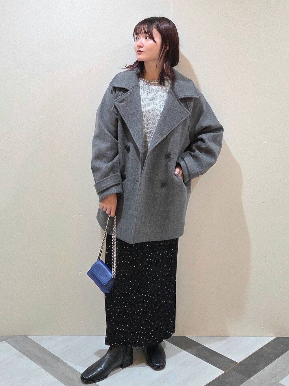 グレー系のピーコート、その他のスカート、ブラック系のブーツを着用したレディースの秋コーディネートの6枚目の写真