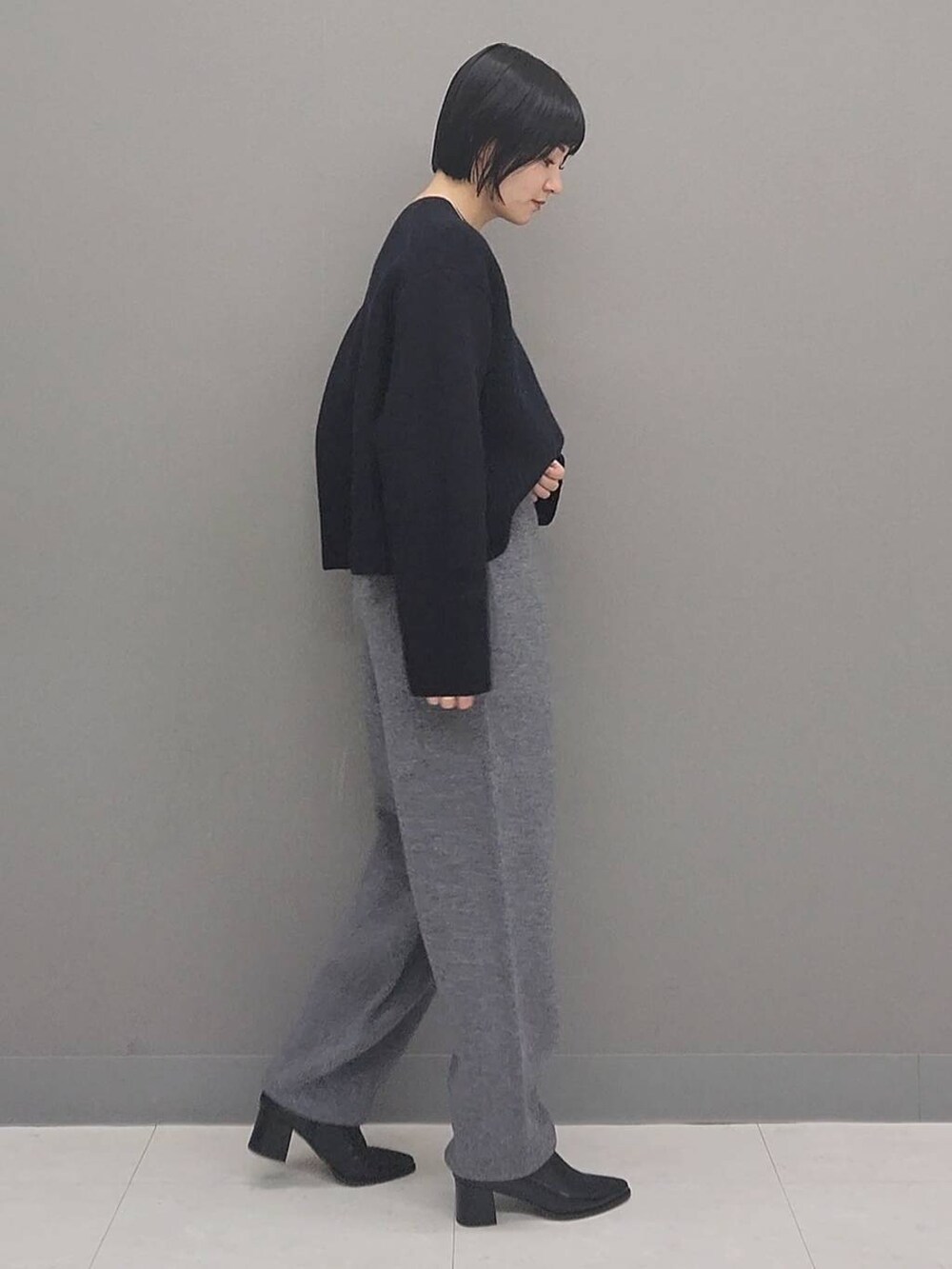 ブルー系のニット/セーター、グレー系のその他パンツ、ブラック系のブーツを着用したレディースの秋コーディネートの2枚目の写真