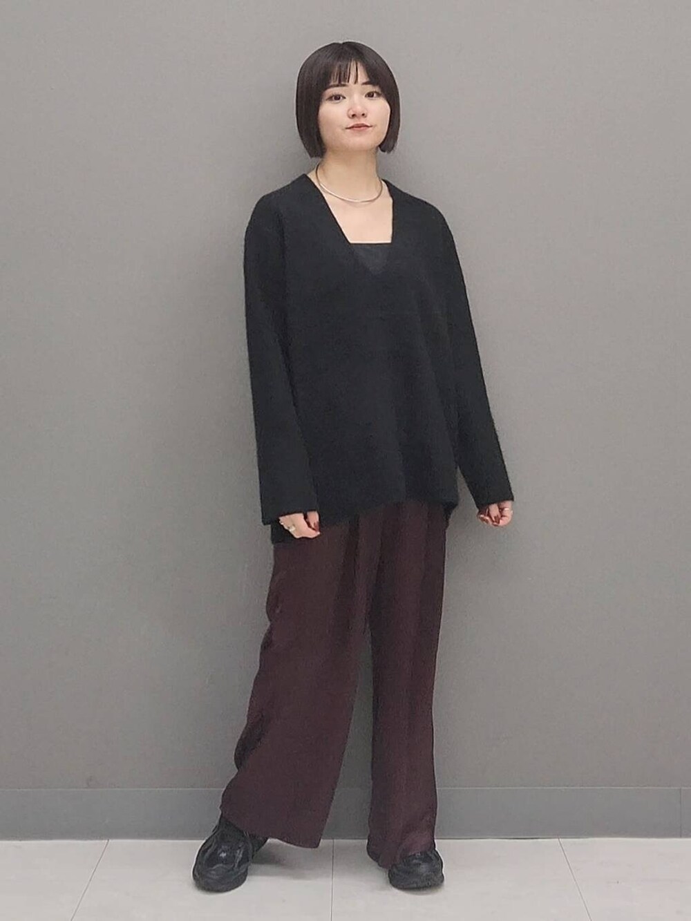 ブラック系のニット/セーター、レッド系のその他パンツ、シルバー系のチョーカーを着用したレディースの秋コーディネートの4枚目の写真