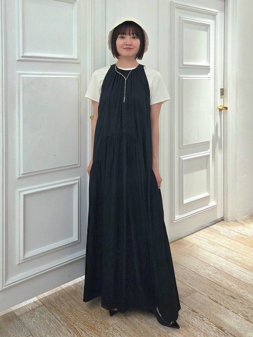 ブラック系のサンダル、ホワイト系のTシャツ/カットソー、ブラック系のワンピースを着用したレディースの春コーディネートの6枚目の写真