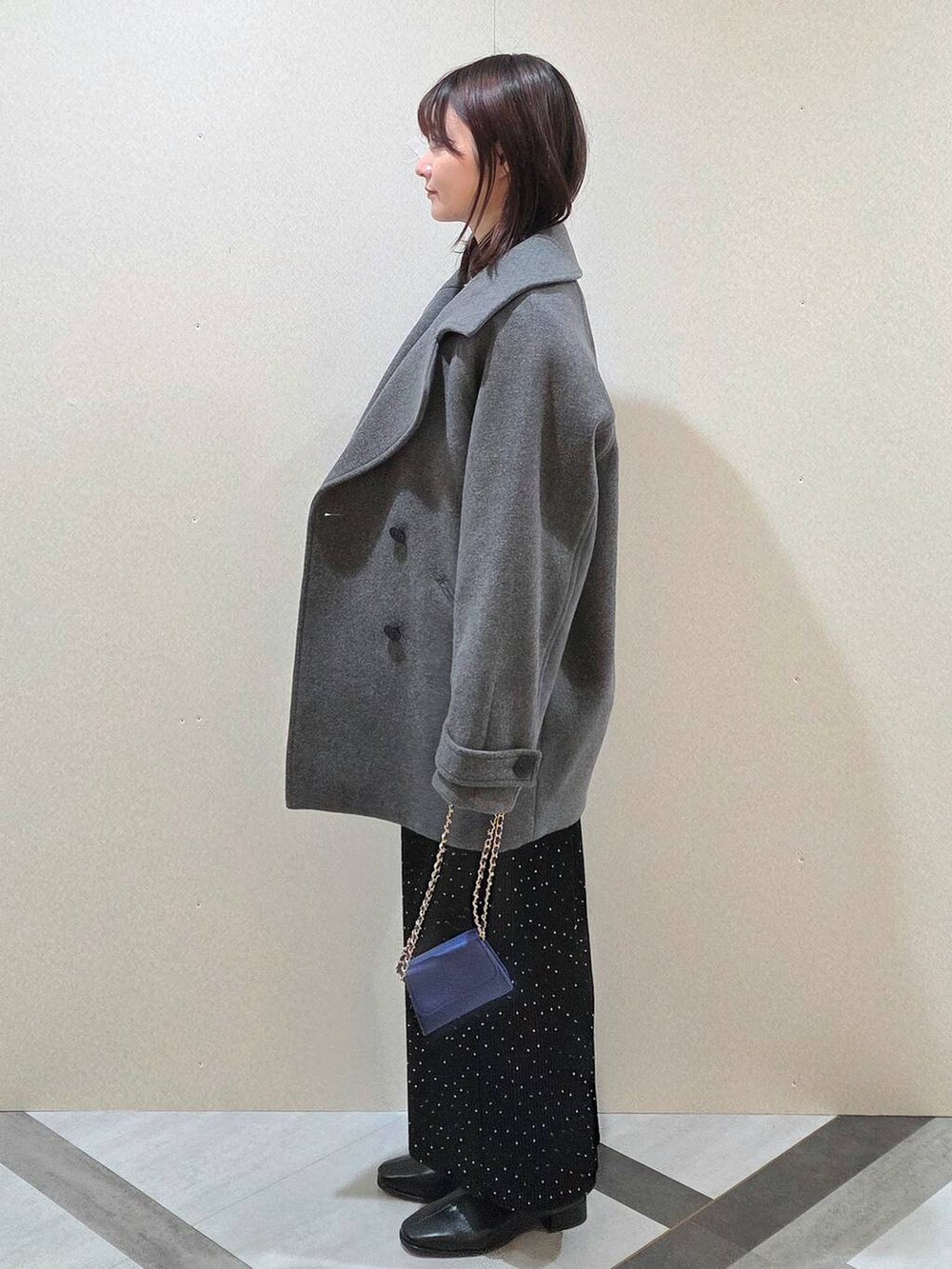 グレー系のピーコート、その他のスカート、ブラック系のブーツを着用したレディースの秋コーディネートの3枚目の写真