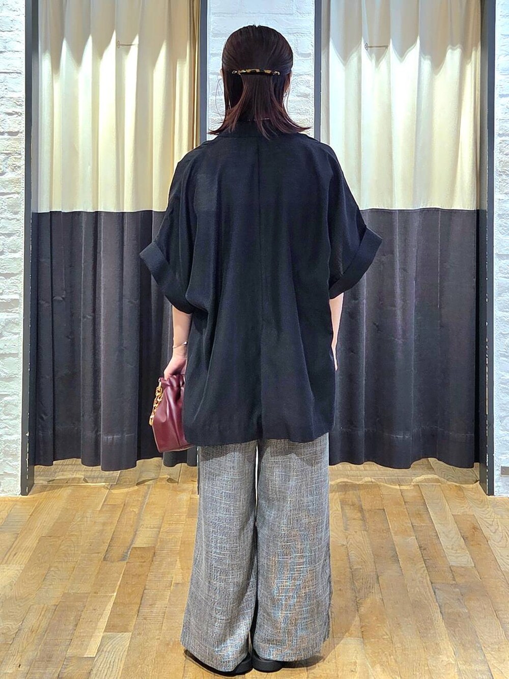 ブラック系のスラックス、レッド系のショルダーバッグ、ブラック系のサンダルを着用したレディースの秋コーディネートの4枚目の写真