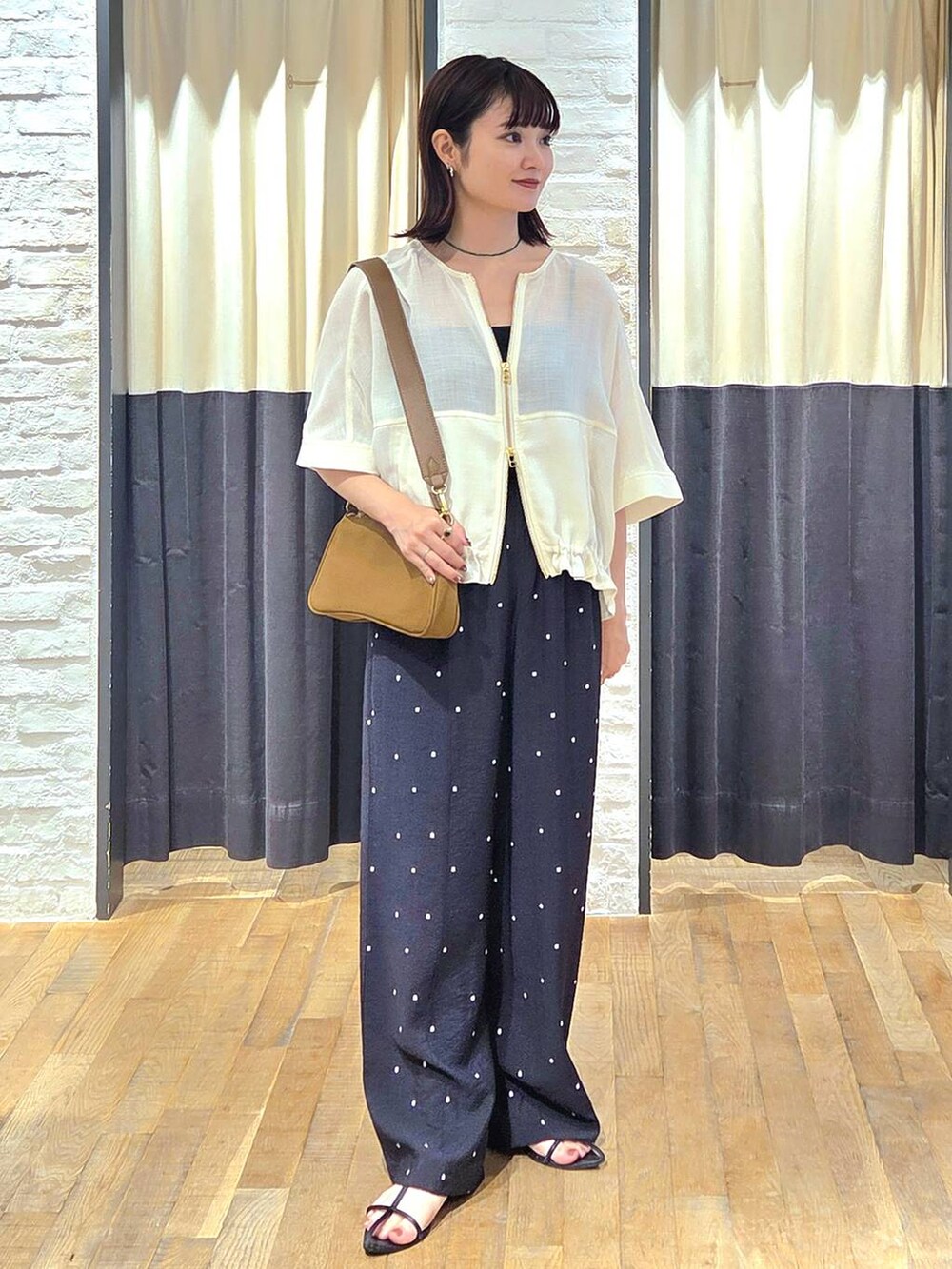 ブラック系のサンダル、ブラック系のその他パンツ、ホワイト系のブルゾンを着用したレディースの夏コーディネートの5枚目の写真