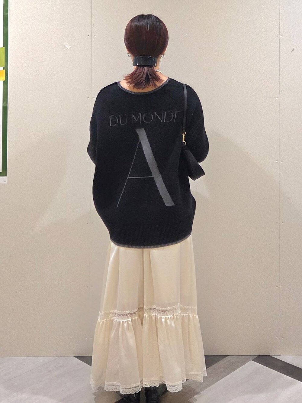 ブラック系のローファー、ブラック系のショルダーバッグ、ホワイト系のスカートを着用したレディースの秋コーディネートの4枚目の写真