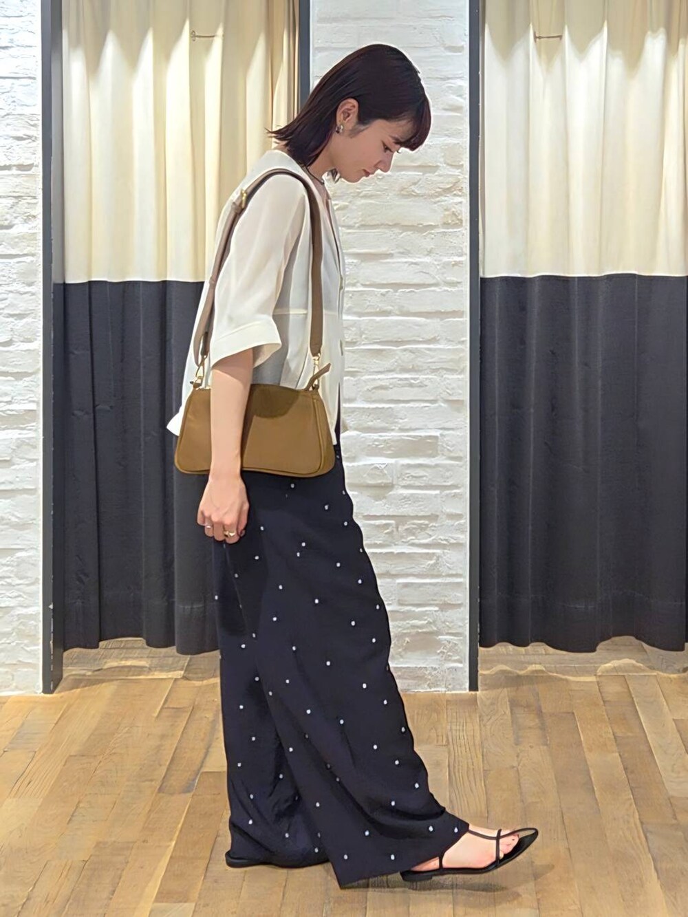 ブラック系のサンダル、ブラック系のその他パンツ、ホワイト系のブルゾンを着用したレディースの夏コーディネートの2枚目の写真