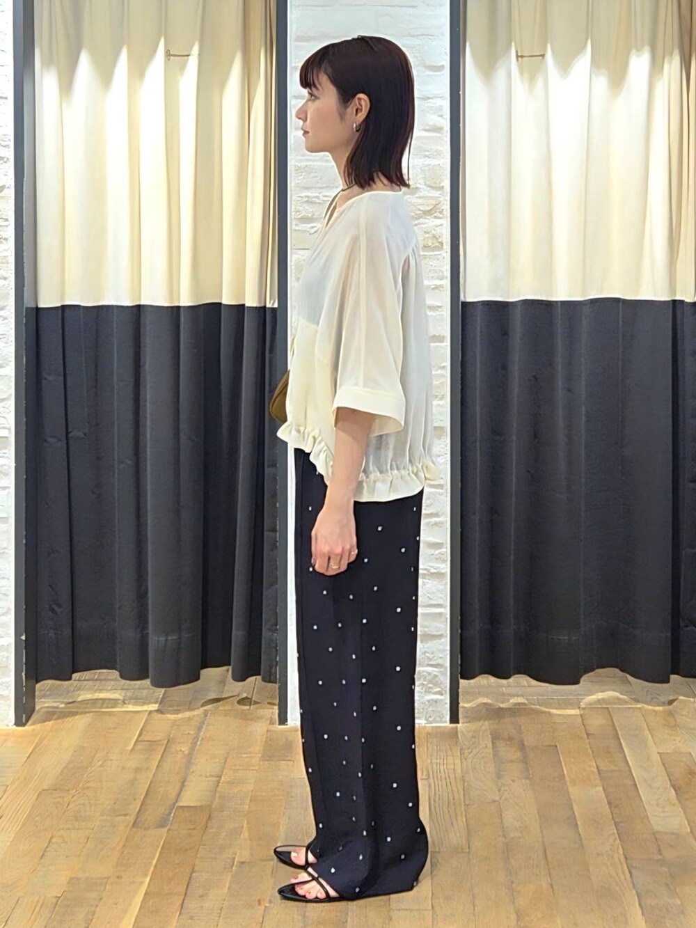 ブラック系のサンダル、ブラック系のその他パンツ、ホワイト系のブルゾンを着用したレディースの夏コーディネートの4枚目の写真