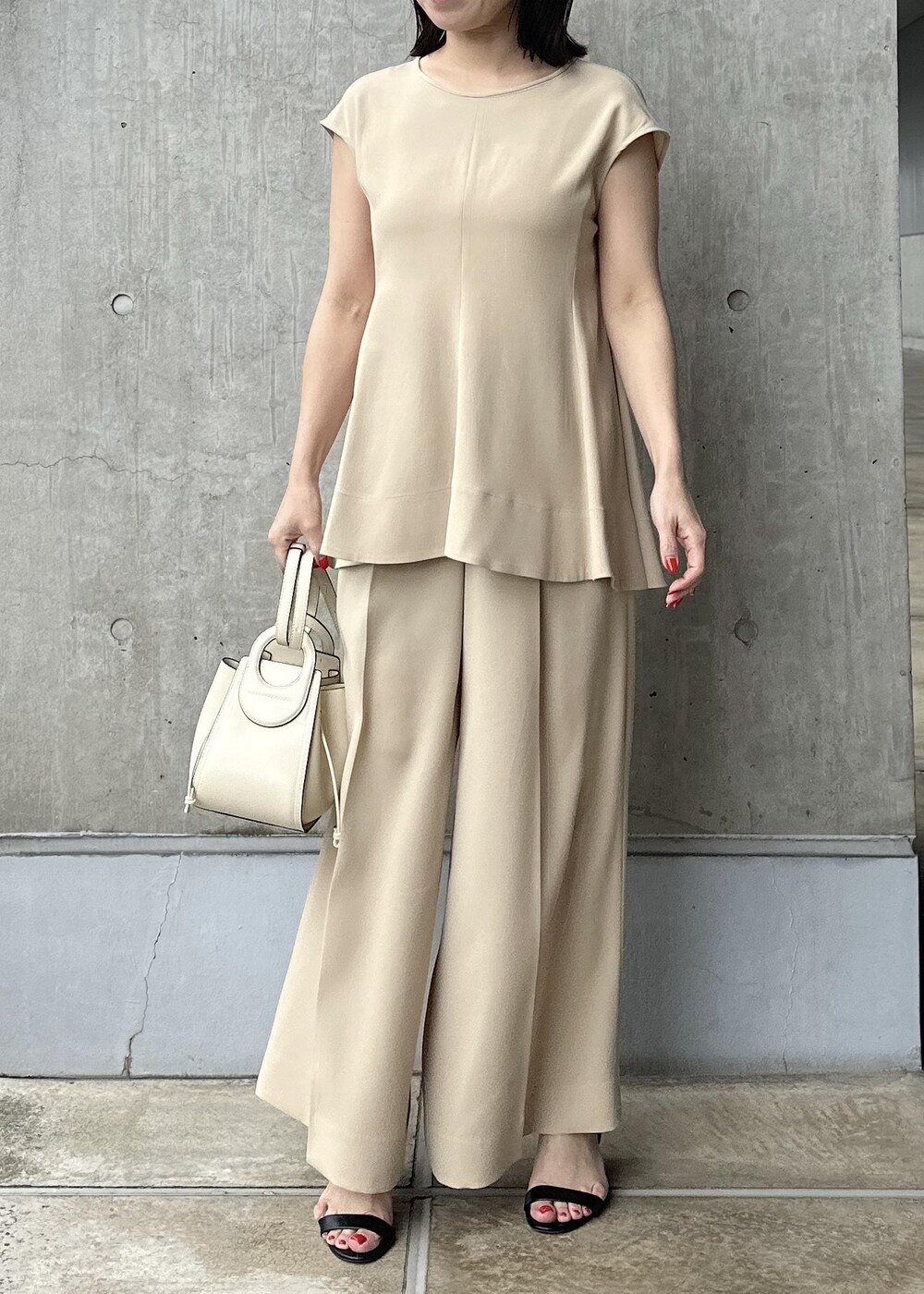 ホワイト系のハンドバッグ、ベージュ系のシャツ/ブラウス、ベージュ系のその他パンツを着用したレディースの夏コーディネートの6枚目の写真