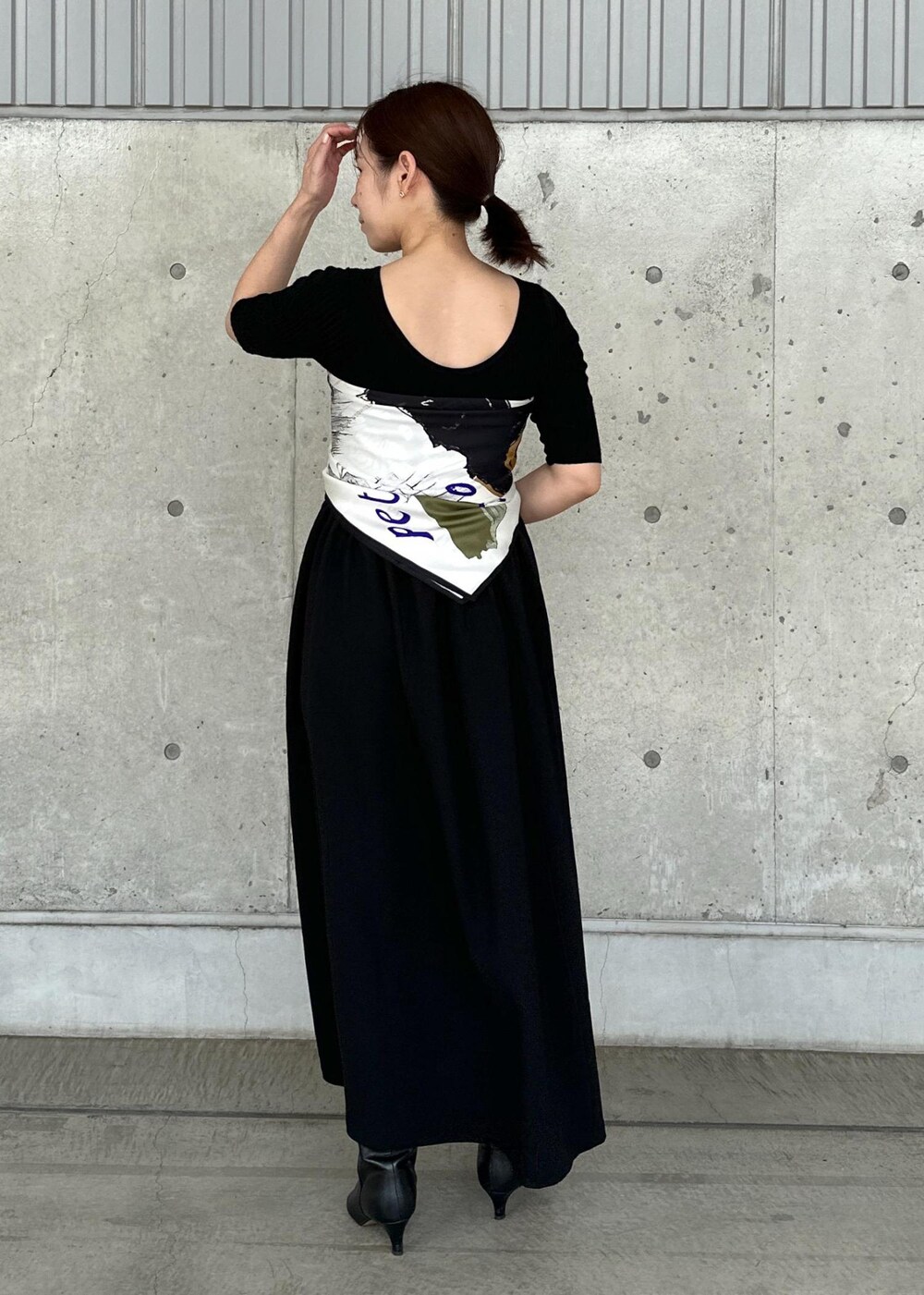 ホワイト系のデニムジャケット、ブルー系のハンドバッグ、ブラック系のワンピースを着用したレディースの秋コーディネートの5枚目の写真