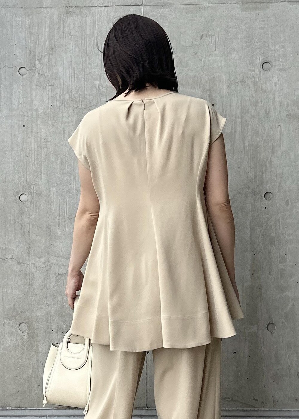 ホワイト系のハンドバッグ、ベージュ系のシャツ/ブラウス、ベージュ系のその他パンツを着用したレディースの夏コーディネートの5枚目の写真