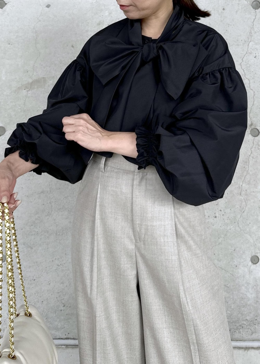 ブラック系のブーツ、ホワイト系のハンドバッグ、ベージュ系のその他パンツを着用したレディースの秋コーディネートの5枚目の写真