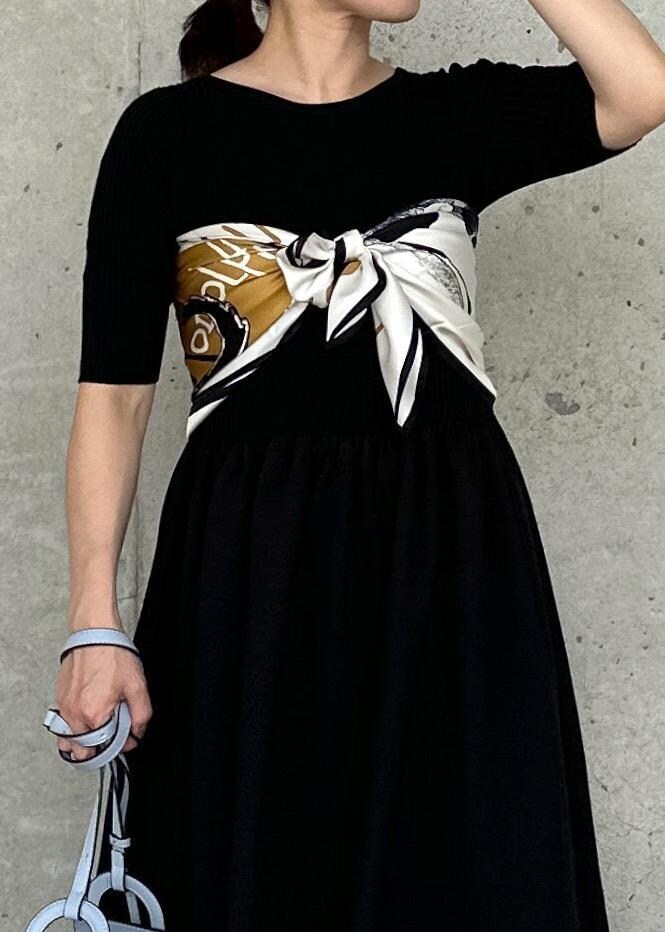 ホワイト系のデニムジャケット、ブルー系のハンドバッグ、ブラック系のワンピースを着用したレディースの秋コーディネートの6枚目の写真