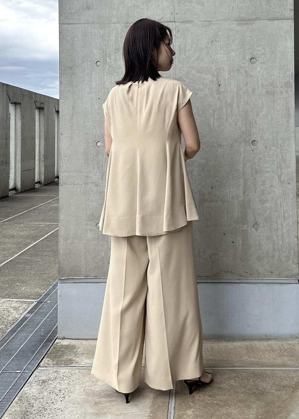 ホワイト系のハンドバッグ、ベージュ系のシャツ/ブラウス、ベージュ系のその他パンツを着用したレディースの夏コーディネートの4枚目の写真