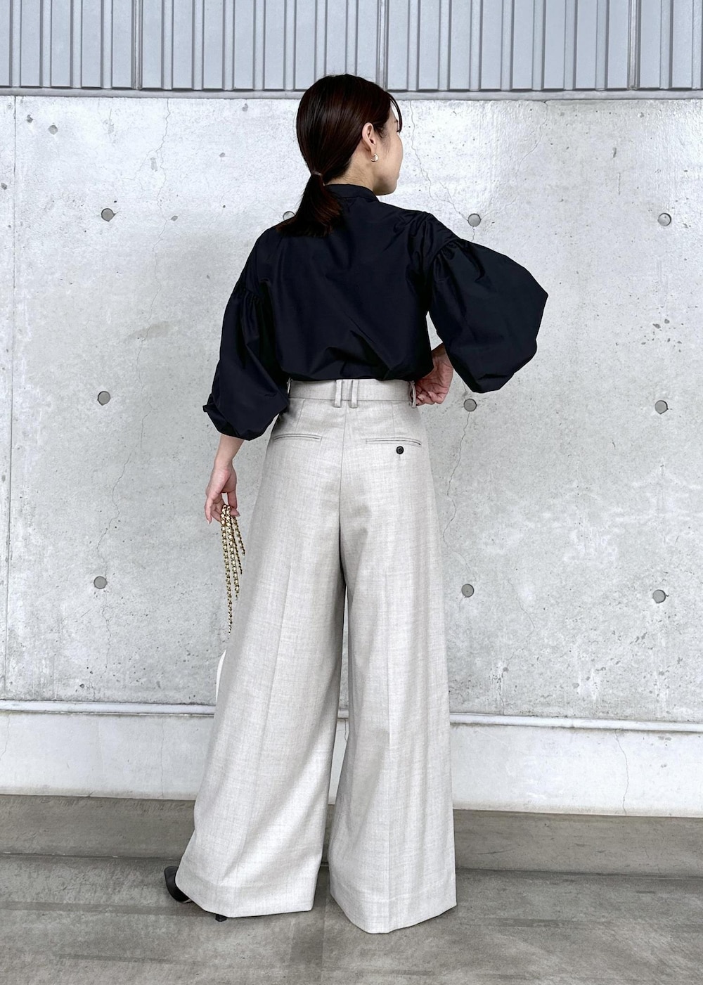 ブラック系のブーツ、ホワイト系のハンドバッグ、ベージュ系のその他パンツを着用したレディースの秋コーディネートの4枚目の写真