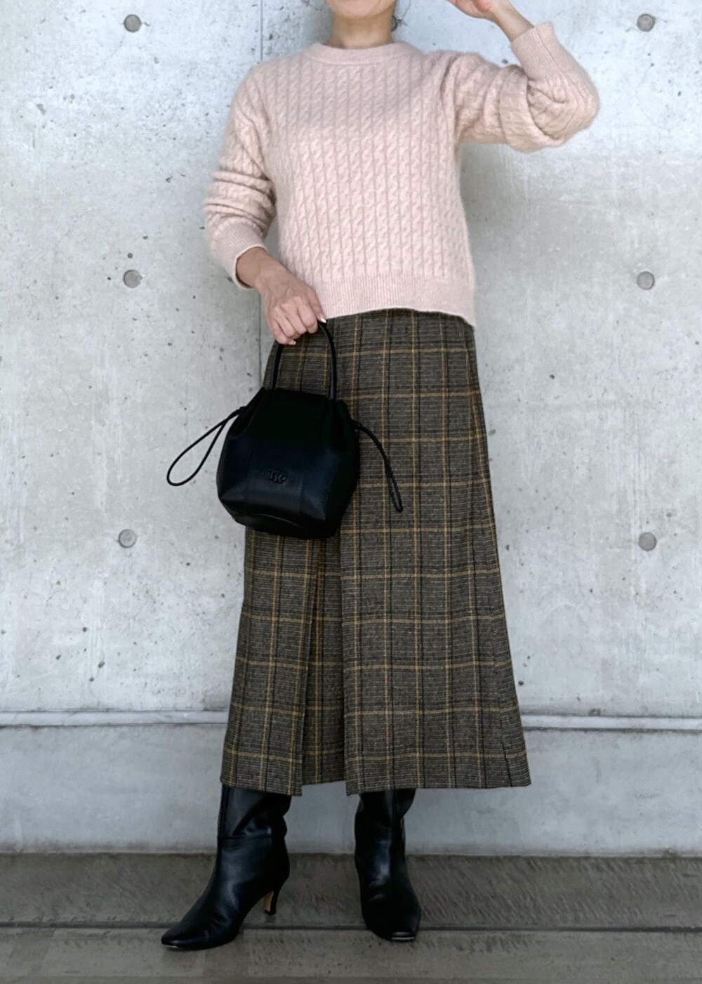 ブラック系のハンドバッグ、ブラック系のブーツ、ホワイト系のダウンジャケット/コートを着用したレディースの秋コーディネートの5枚目の写真