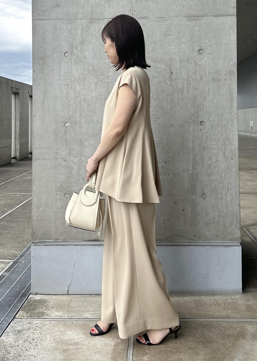 ホワイト系のハンドバッグ、ベージュ系のシャツ/ブラウス、ベージュ系のその他パンツを着用したレディースの夏コーディネートの3枚目の写真