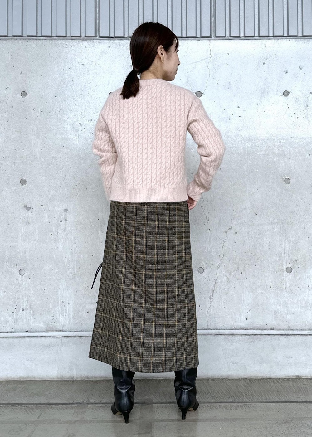 ブラック系のハンドバッグ、ブラック系のブーツ、ホワイト系のダウンジャケット/コートを着用したレディースの秋コーディネートの4枚目の写真