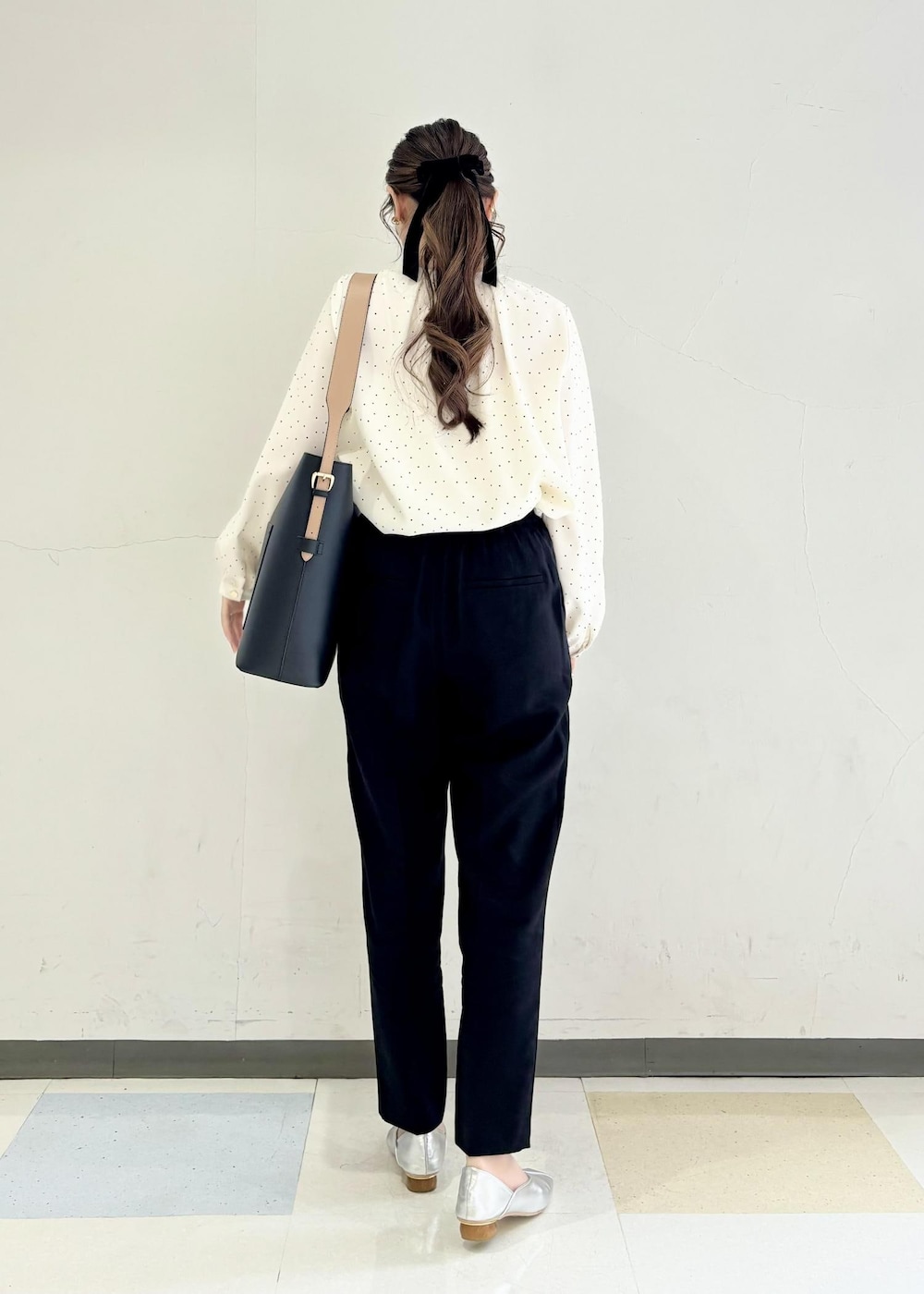 シルバー系のパンプス、ホワイト系のシャツ/ブラウス、ブラック系のスラックスを着用したレディースの春コーディネートの3枚目の写真