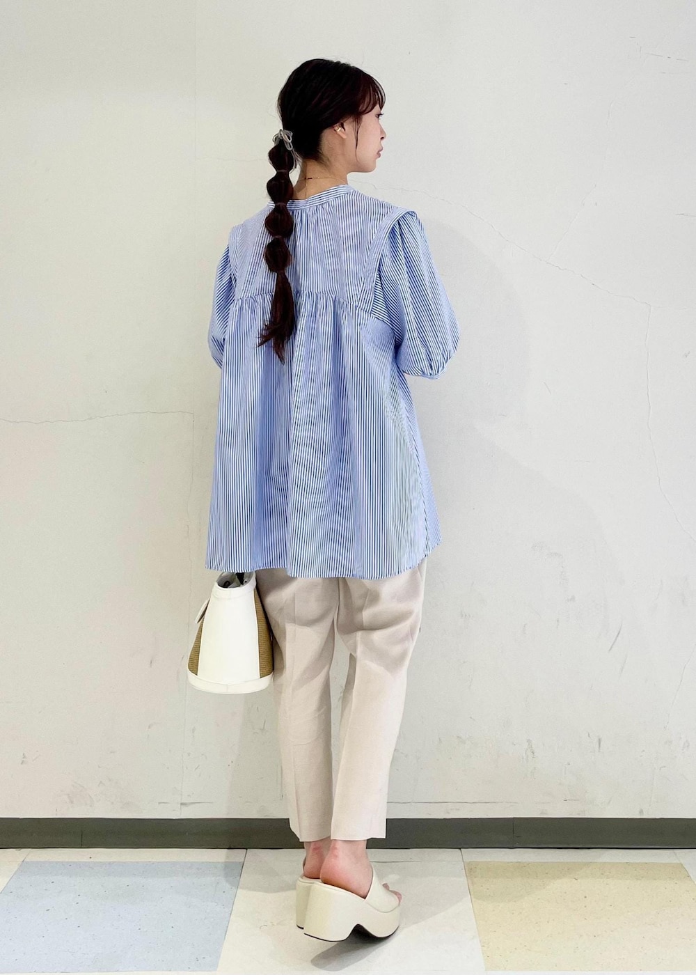 ブルー系のシャツ/ブラウス、ホワイト系のサンダル、ホワイト系のスラックスを着用したレディースの春コーディネートの3枚目の写真