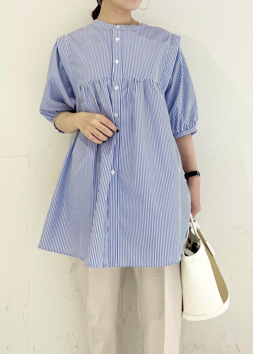 ブルー系のシャツ/ブラウス、ホワイト系のサンダル、ホワイト系のスラックスを着用したレディースの春コーディネートの4枚目の写真