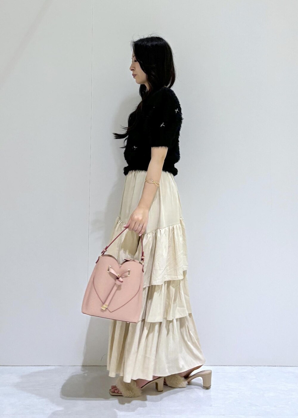 ベージュ系のドレスシューズ、ベージュ系のスカート、ブラック系のニット/セーターを着用したレディースの夏コーディネートの3枚目の写真