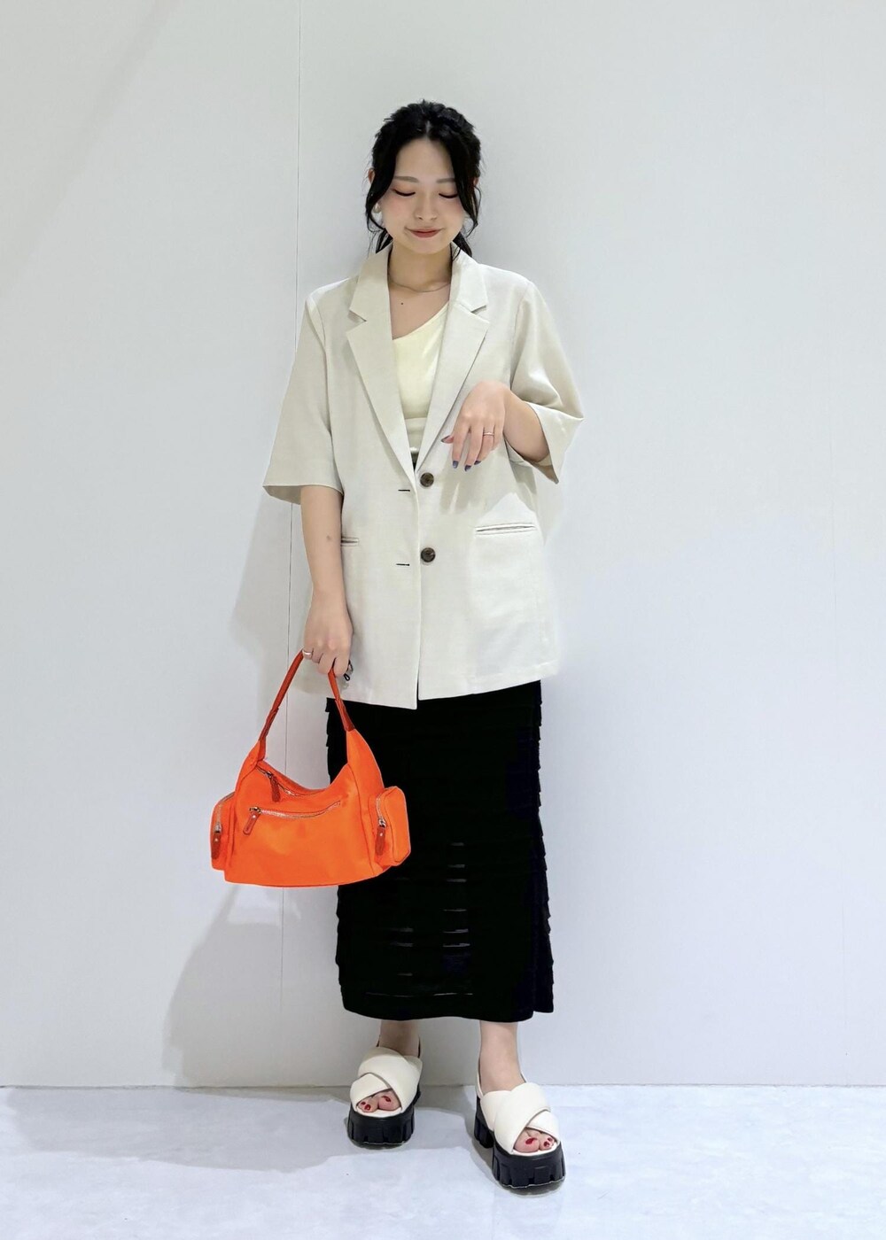 ホワイト系のサンダル、ブラック系のスカート、ホワイト系のタンクトップを着用したレディースの夏コーディネートの5枚目の写真